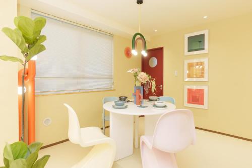 a dining room with a white table and chairs at 寅ホテル 御徒町 TORA HOTEL Okachimachi in Tokyo