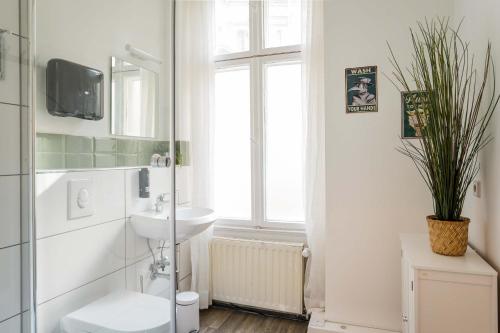 a bathroom with a sink and a toilet and a window at LUXURY at Rosenthaler Platz in Berlin