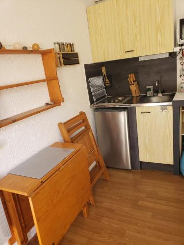- une cuisine avec une table et un banc dans une pièce dans l'établissement Studio douillet à Puy-Saint-Vincent, 16 m², vue sur la montagne., à Puy-Saint-Vincent