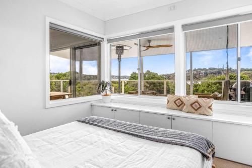 a bedroom with a bed and large windows at Sensational Ocean Views In Maianbar in Maianbar