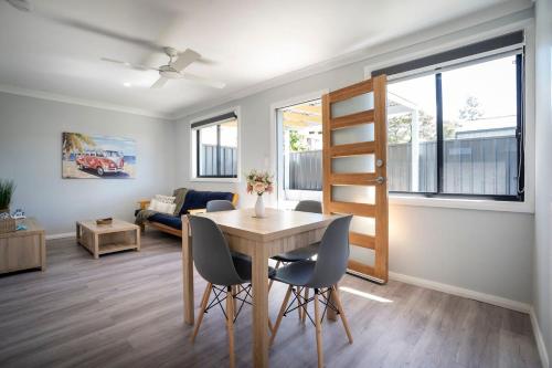 ein Esszimmer und ein Wohnzimmer mit Tisch und Stühlen in der Unterkunft Rosa Beach Studio Getaway in Vincentia