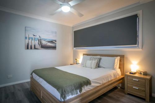 Schlafzimmer mit einem Bett und einem großen Wandschirm in der Unterkunft Rosa Beach Studio Getaway in Vincentia