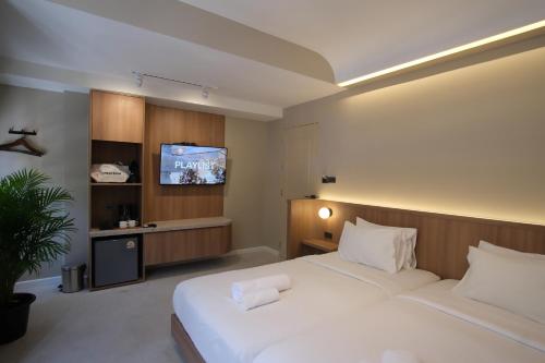 a bedroom with two beds and a flat screen tv at Urban room samed in Ko Samed
