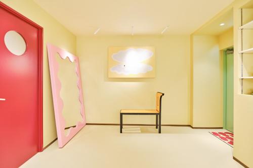a room with a chair and a painting on the wall at 寅ホテル 御徒町 TORA HOTEL Okachimachi in Tokyo