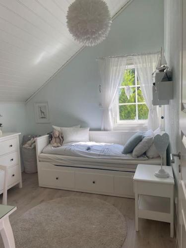 a white bedroom with a bed with a window at Drømmested for idylliske dager in Skjoldastraumen