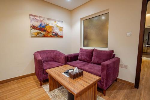 a living room with a purple couch and a table at مسكن نال in Abha