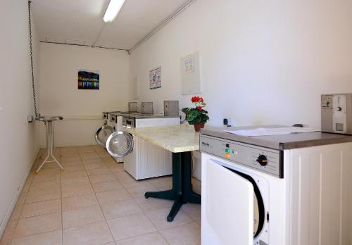Cette chambre comprend une cuisine équipée d'une cuisinière et d'une table. dans l'établissement Residence Alba Rossa, à Serra-di-Ferro
