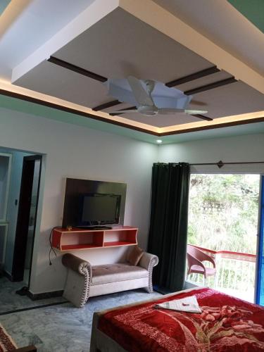 a bedroom with a ceiling with a tv and a bed at Hotel Red Roof & Restaurant in Abbottābād