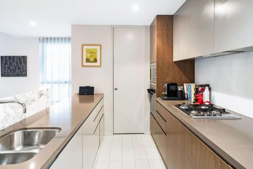 a kitchen with a sink and a counter top at Leafy Inner City Apartment Camperdown in Sydney