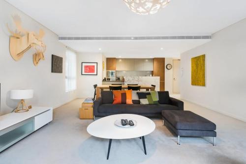 a living room with a couch and a table at Leafy Inner City Apartment Camperdown in Sydney