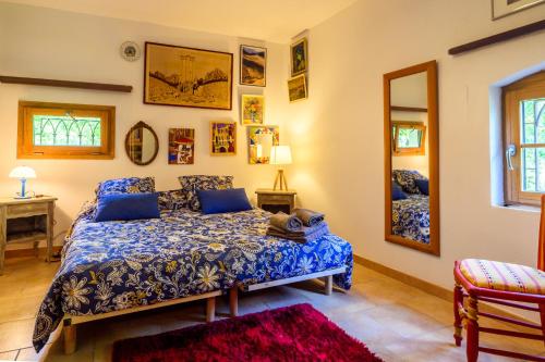 une chambre avec un lit bleu et un miroir dans l'établissement Moulin St Pierre bord de Rivière, à Limoux