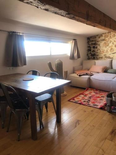 un salon avec une table, des chaises et un canapé dans l'établissement Le Loft Cosy - Centre ville - Cadre Royal, à Sète