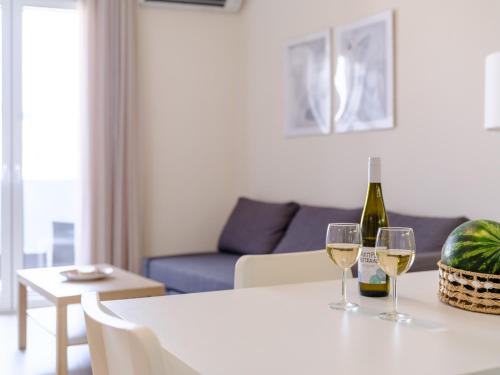 a living room with a table with two glasses of wine at Pietra Sole in Ierápetra