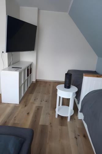 a bedroom with a tv and a table with a stool at Bei Heike in Zetel
