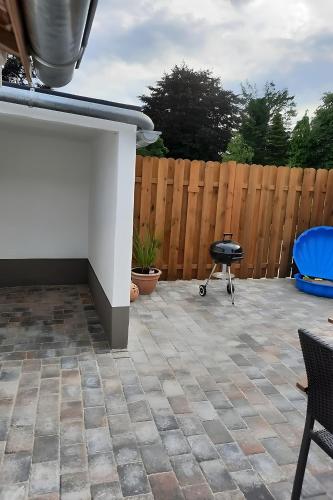 a patio with a grill and a fence at Bei Heike in Zetel