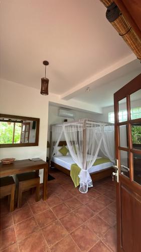 a bedroom with a bed and a table and a table at Beach Club Apartments in Induruwa
