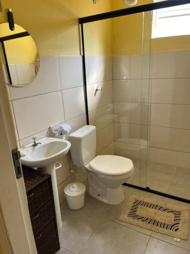 a bathroom with a toilet and a sink and a shower at Apto. em Conceição dos Ouros MG in Conceição dos Ouros