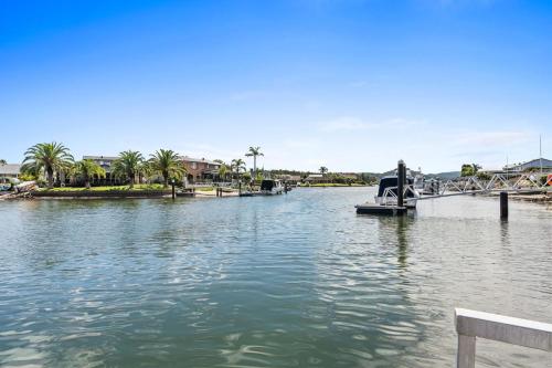 a body of water with a bridge and palm trees at Waterfront Luxury Pool-Spa-Jetty-Pool Table in Daleys Point