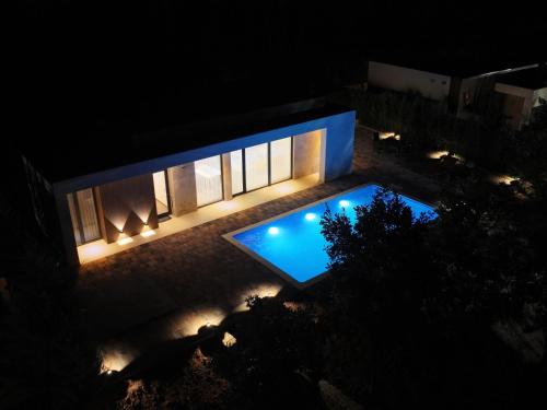 a house with a swimming pool at night at Brick Villas - Poolside Bliss in Novoberdo