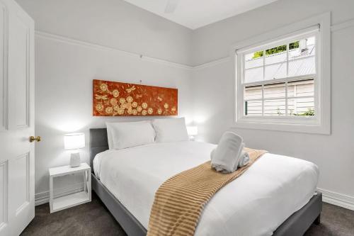 a white bedroom with a bed and a window at Loch Lomond Home Mountain Retreat Katoomba in Katoomba