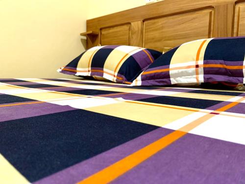a bed with colorful pillows on it at Luxury apartment Yaoundé in Mimboman