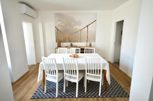 une salle à manger avec une table blanche et des chaises blanches dans l'établissement Épernay Prestige, Appartement avec terrasse, à Épernay