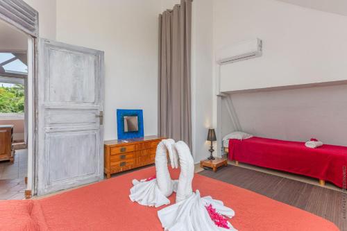 a bedroom with a red bed and a red bed at KaruHuapi in Le Gosier