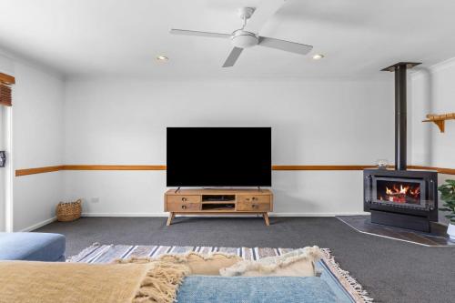 a living room with a tv and a fireplace at Serene Family Paradise in Pelican Flat