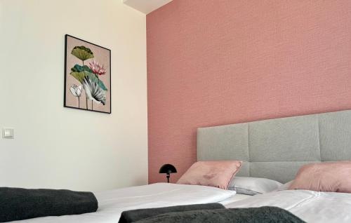 una camera con due letti e una parete rosa di The Loft a Gmunden