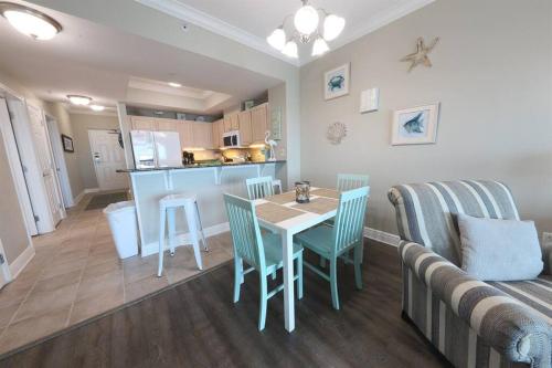 eine Küche und ein Wohnzimmer mit Tisch und Stühlen in der Unterkunft 10th Floor Crystal Tower 2 Bedroom Condo with 2 Outdoor Pools, Lazy River, Heated Indoor Pool, and Direct Beach Access in Gulf Shores