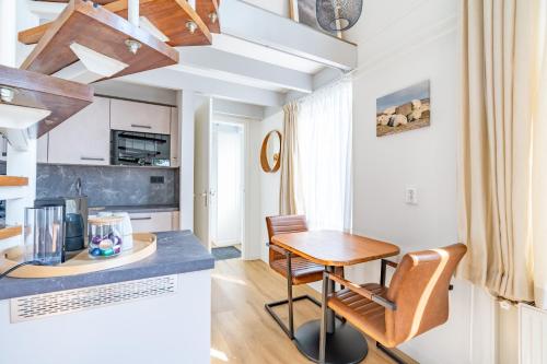 a kitchen and dining room with a table and chairs at Plevierstraat 3a in De Koog