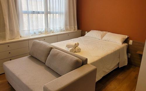 a bedroom with a bed and a couch with a stuffed animal on it at Blend Coliving One - 2b in Ribeirão Preto