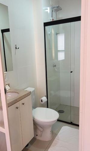 a bathroom with a toilet and a glass shower at Blend Coliving One - 2b in Ribeirão Preto