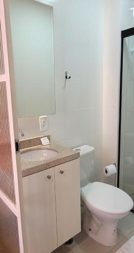 a bathroom with a toilet and a sink and a mirror at Blend Coliving One - 2b in Ribeirão Preto