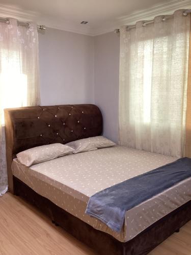 a bed sitting in a bedroom with curtains at Lovely Familia Inn in Machang