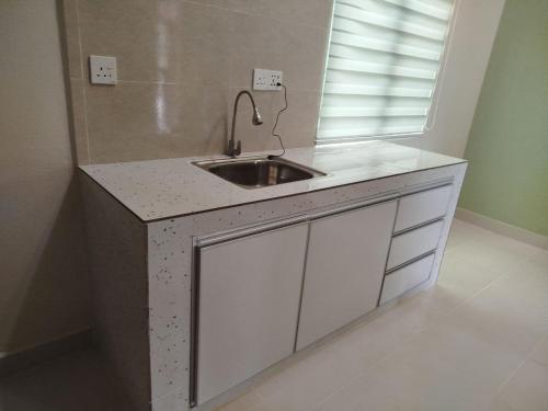 a kitchen counter with a sink and a window at Lovely Familia Inn in Machang