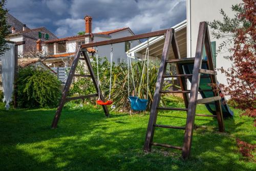 une balançoire en bois installée dans une cour avec un frisbee dans l'établissement Villa Laura Krnica near Pula for 8 people - pet friendly with children playground, à Krnica