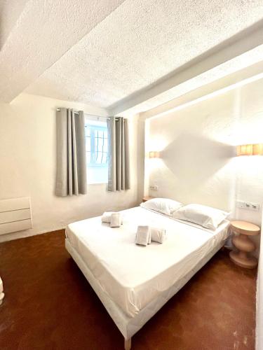 une chambre avec un lit blanc avec des serviettes dessus dans l'établissement Le Suquet - Charming apartment, à Cannes