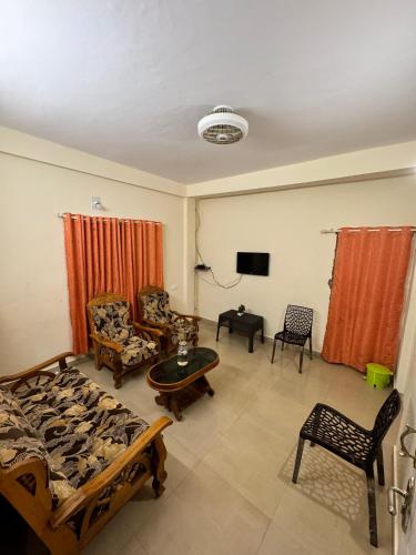 Una sala de estar con un sofá y un televisor. en Farm Stay - Apple Valley, en Kanthalloor