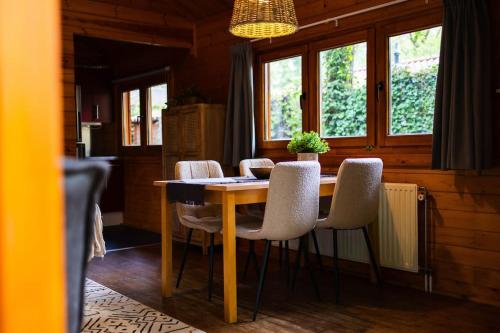 a dining room with a table and chairs at Huisdiervriendelijk houten huisje in het groen in Epe