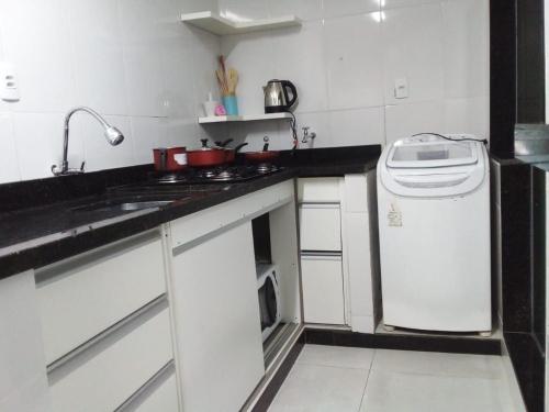 a kitchen with a sink and a stove and a dishwasher at Apto 2 quartos Nucleo Bandeirante in Brasilia