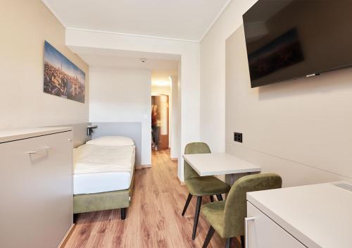 a small room with a bed and a table and chairs at Hotel Pickwick and Pub "the room with a view" in Luzern