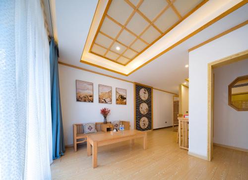 a living room with a table and a ceiling at Zhangjiajie DreamWay Hotel - Free pick up service in Zhangjiajie