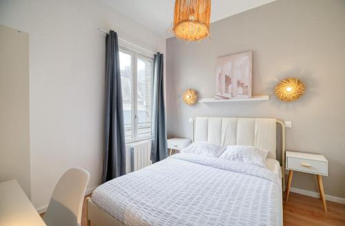 une chambre avec un lit blanc et une fenêtre dans l'établissement Le Grand Bammeville -- 337, à Rouen
