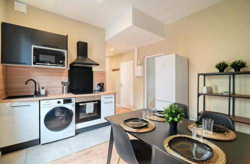 une cuisine avec une table à manger et une cuisine avec un lave-linge dans l'établissement Le Grand Bammeville -- 337, à Rouen