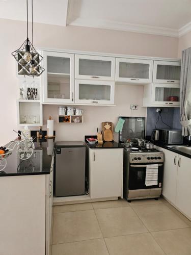 kuchnia z białymi szafkami i kuchenką w obiekcie Alsander Homes Raspberry w mieście Kampala