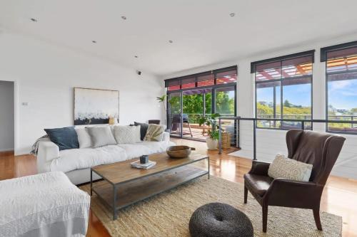 a living room with a couch and a table at Hilltop Hideaway Family Escape in Merewether