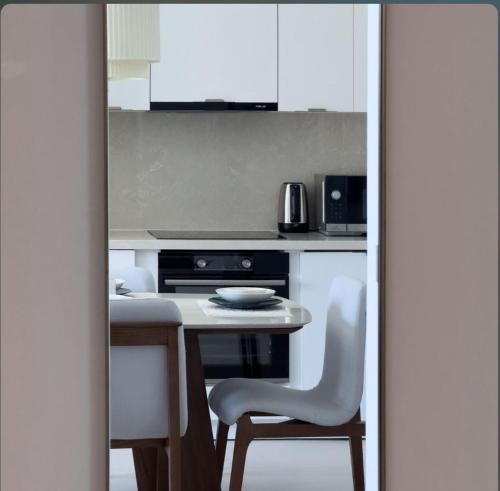 a kitchen with a table and two white chairs at Vida Marassi Marina Two Bedroom Hotel Apartment in El Alamein