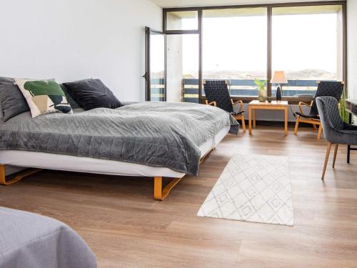 a bedroom with a bed and a table and chairs at Apartment in Holiday Park in Vederso Klit in Ulfborg