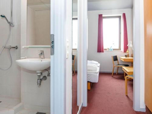 a bathroom with a sink and a room with a table at Apartment in Holiday Park in Vederso Klit in Ulfborg